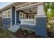 Inviting porch offers brick supports, crisp white railing, and a relaxing swing for enjoying the outdoors at 121 W Mohawk Ave, Tampa, FL 33604