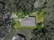 Aerial view showcasing property's boundaries, lawn, driveway, and proximity to trees at 131 Oak Park Ave, Brooksville, FL 34601