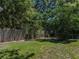Green backyard featuring a wood privacy fence, chain link fence, lush trees, and green grass at 131 Oak Park Ave, Brooksville, FL 34601