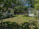 Lush backyard featuring a storage shed, air conditioning condenser, and green grass at 131 Oak Park Ave, Brooksville, FL 34601
