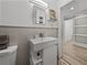 Bathroom with gray tile, modern vanity, and sliding barn door access at 131 Oak Park Ave, Brooksville, FL 34601