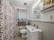 Bathroom features a modern vanity, patterned shower curtain, and gray tile at 131 Oak Park Ave, Brooksville, FL 34601