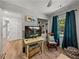 Relaxing bedroom featuring a TV, rocking chair with a view of the yard, and light wood-look flooring at 131 Oak Park Ave, Brooksville, FL 34601