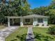Charming single-story home with a carport, front porch with chairs, and well-maintained lawn at 131 Oak Park Ave, Brooksville, FL 34601