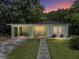 Charming single-story home with a carport, front porch with chairs, and well-maintained lawn at sunset at 131 Oak Park Ave, Brooksville, FL 34601