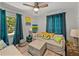 Cozy living room with a ceiling fan, light gray walls, colorful pillows, and bright natural light from the window at 131 Oak Park Ave, Brooksville, FL 34601