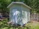 Close up of a green storage shed featuring a white door, green siding, and a small set of stairs at 131 Oak Park Ave, Brooksville, FL 34601