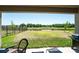 View of the landscaped backyard and pond from a covered patio with a grill and some outdoor furniture at 14623 Horse Trot Rd, Lithia, FL 33547