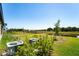 Expansive lawn with green shrubs and lawn equipment, bordering a serene pond and neighborhood at 14623 Horse Trot Rd, Lithia, FL 33547