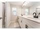 Modern bathroom featuring double vanity with sleek fixtures, a large mirror, and a window for natural light at 14623 Horse Trot Rd, Lithia, FL 33547