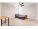 Neutral toned bedroom with a ceiling fan, light-colored walls, and a simple bed and desk space at 14623 Horse Trot Rd, Lithia, FL 33547