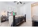 Inviting bedroom features an iron bed, ceiling fan, and soft natural light, creating a relaxing personal space at 14623 Horse Trot Rd, Lithia, FL 33547