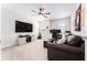 Comfortable bedroom space with a ceiling fan, entertainment center and desk, plus neutral-toned walls and carpet at 14623 Horse Trot Rd, Lithia, FL 33547