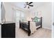 Cozy bedroom with a black iron bed, ceiling fan, and natural light from the window, creating a serene retreat at 14623 Horse Trot Rd, Lithia, FL 33547