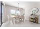 Bright dining room with wood table, six chairs, modern chandelier, and a convenient bar cart for entertaining at 14623 Horse Trot Rd, Lithia, FL 33547