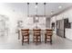 Bright kitchen features a central island with seating, modern pendant lighting, and stainless steel appliances for convenient cooking at 14623 Horse Trot Rd, Lithia, FL 33547