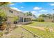 Wide backyard featuring a brick walkway, patio, mature landscaping, and screened in porch at 15034 Newport Rd, Clearwater, FL 33764