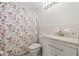 Clean bathroom features a shower with a floral curtain and vanity with white countertop at 15034 Newport Rd, Clearwater, FL 33764