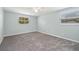 This cozy bedroom features new gray carpeting and bright natural light at 15034 Newport Rd, Clearwater, FL 33764