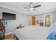 Bedroom with a ceiling fan and a wall-mounted TV, offering comfort and entertainment at 15034 Newport Rd, Clearwater, FL 33764