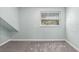 A simple bedroom with gray carpeting and a window with wooded view at 15034 Newport Rd, Clearwater, FL 33764