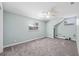 Bright bedroom featuring gray carpet, two windows and a ceiling fan at 15034 Newport Rd, Clearwater, FL 33764