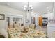 Open-concept dining room with modern chandelier and view into living room and kitchen at 15034 Newport Rd, Clearwater, FL 33764