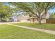 Two-story home with a well-kept lawn, mature shade tree, and a driveway leading to a garage at 15034 Newport Rd, Clearwater, FL 33764
