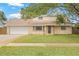 Charming home with a brick-accented front, a well-manicured lawn, and an attached two-car garage at 15034 Newport Rd, Clearwater, FL 33764
