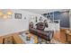Cozy living area with a sectional couch, decorative shelving, and access to the dining room at 15034 Newport Rd, Clearwater, FL 33764