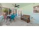 Charming screened-in patio with ceiling fan, dining table, and wooden bench seating at 15034 Newport Rd, Clearwater, FL 33764