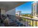 Balcony with seating overlooking the city street, beachfront buildings, and palm trees at 1581 Gulf Blvd # 301N, Clearwater Beach, FL 33767