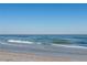 Waves lap the shoreline on a clear, sunny day at the beautiful beach at 1581 Gulf Blvd # 301N, Clearwater Beach, FL 33767