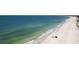 Wide sandy beach with people, azure water, and beachfront condo and hotel buildings in the distance at 1581 Gulf Blvd # 301N, Clearwater Beach, FL 33767