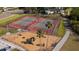 Aerial view of well-maintained tennis courts and playground within a gated community at 1581 Gulf Blvd # 301N, Clearwater Beach, FL 33767