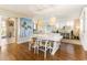 Bright dining room featuring hardwood floors, a modern white table, woven chairs and stylish pendant lighting at 1581 Gulf Blvd # 301N, Clearwater Beach, FL 33767