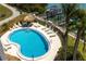 Inviting kidney-shaped pool with lounge chairs and tiki hut near the waterfront at 1581 Gulf Blvd # 301N, Clearwater Beach, FL 33767