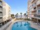 Beautiful pool view with swaying palm trees, blue skies, and ocean backdrop at 16400 Gulf Blvd # 505, North Redington Beach, FL 33708