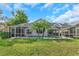 A lovely backyard features a screened-in pool, a patio area, and lush greenery creating a relaxing outdoor space at 18836 Maisons Dr, Lutz, FL 33558