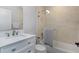 Bathroom featuring a white vanity, tub with shower and glass partition, and neutral wall coverings at 18836 Maisons Dr, Lutz, FL 33558