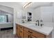 Bathroom showcasing double sink vanity, modern lighting, and a large mirror at 18836 Maisons Dr, Lutz, FL 33558
