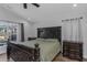 Primary bedroom boasts a large bed, plenty of natural light, and hard wood floors at 18836 Maisons Dr, Lutz, FL 33558