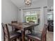 Dining area with a wooden table, seating for four, and sliding glass doors leading to the outdoors at 18836 Maisons Dr, Lutz, FL 33558
