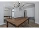 Open dining area featuring wooden table, chandelier, hardwood floors, and views to entry and hallway at 18836 Maisons Dr, Lutz, FL 33558