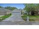 Charming single-story home featuring manicured landscaping and a spacious two-car garage, enhancing its curb appeal at 18836 Maisons Dr, Lutz, FL 33558