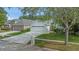 Charming single-story home with a patterned driveway, a two-car garage, and mature trees in a well-kept neighborhood at 18836 Maisons Dr, Lutz, FL 33558