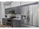 Well-equipped kitchen with gray cabinets, stainless steel appliances, and modern finishes at 18836 Maisons Dr, Lutz, FL 33558