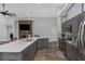 Open kitchen design with stone fireplace, an island, stainless steel appliances, and gray cabinets at 18836 Maisons Dr, Lutz, FL 33558