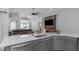 Modern kitchen with an open concept, showcasing the island, stone fireplace and stainless appliances at 18836 Maisons Dr, Lutz, FL 33558