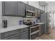 Well-equipped kitchen with stainless steel appliances, sleek gray cabinets, and modern countertops at 18836 Maisons Dr, Lutz, FL 33558